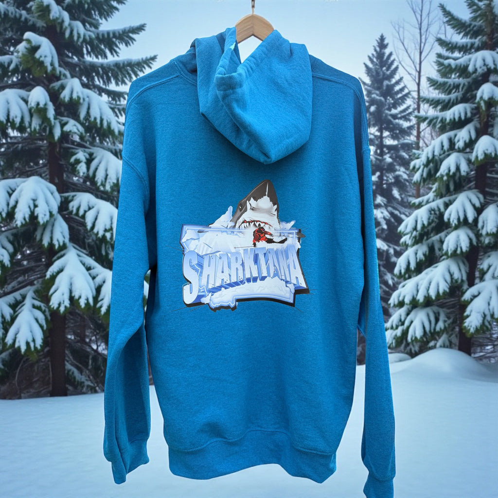 Blue hoodie with a Sharktana logo on a hanger against a snowy forest background